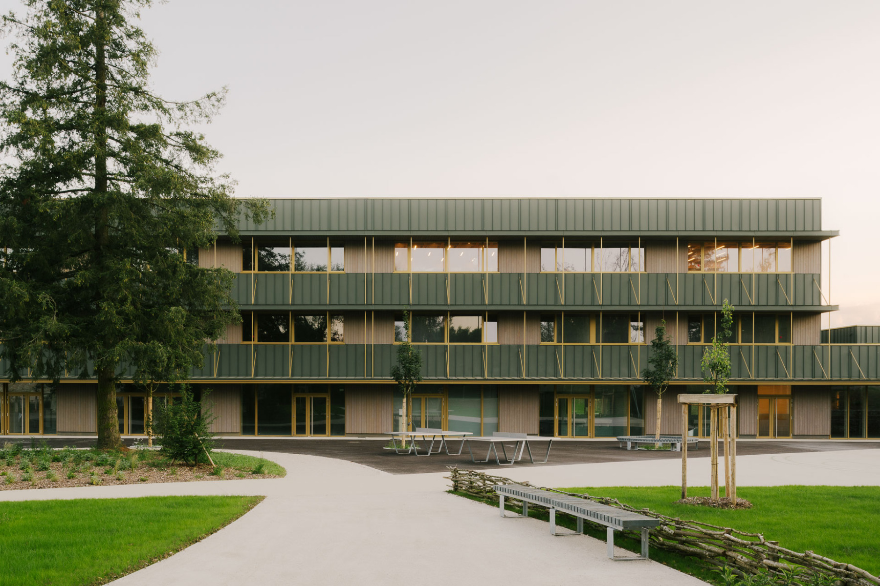 The&#x20;Coll&#xE8;ge&#x20;Maryse&#x20;Bastie&#x20;dates&#x20;back&#x20;to&#x20;the&#x20;1970s.&#x20;During&#x20;its&#x20;renovation,&#x20;it&#x20;was&#x20;given&#x20;a&#x20;new,&#x20;uniform&#x20;exterior&#x20;comprising&#x20;green&#x20;standing&#x20;seam&#x20;metal,&#x20;grey&#x20;glazed&#x20;larch&#x20;wood&#x20;cladding,&#x20;and&#x20;striking&#x20;yellow&#x20;window&#x20;frames.&#x20;&#xA9;&#x20;Maxime&#x20;Verret&#x20;&#x20;