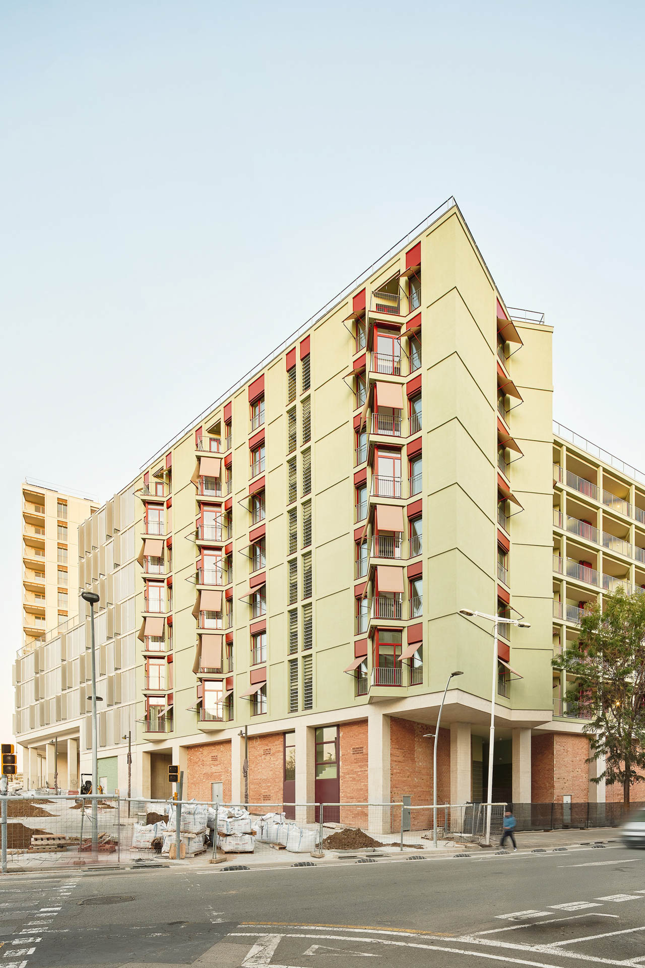 Über dem hohen Gebäudesockel aus Beton und Ziegeln erheben sich sieben farbenfroh gestaltete Wohngeschosse. © José Hevia