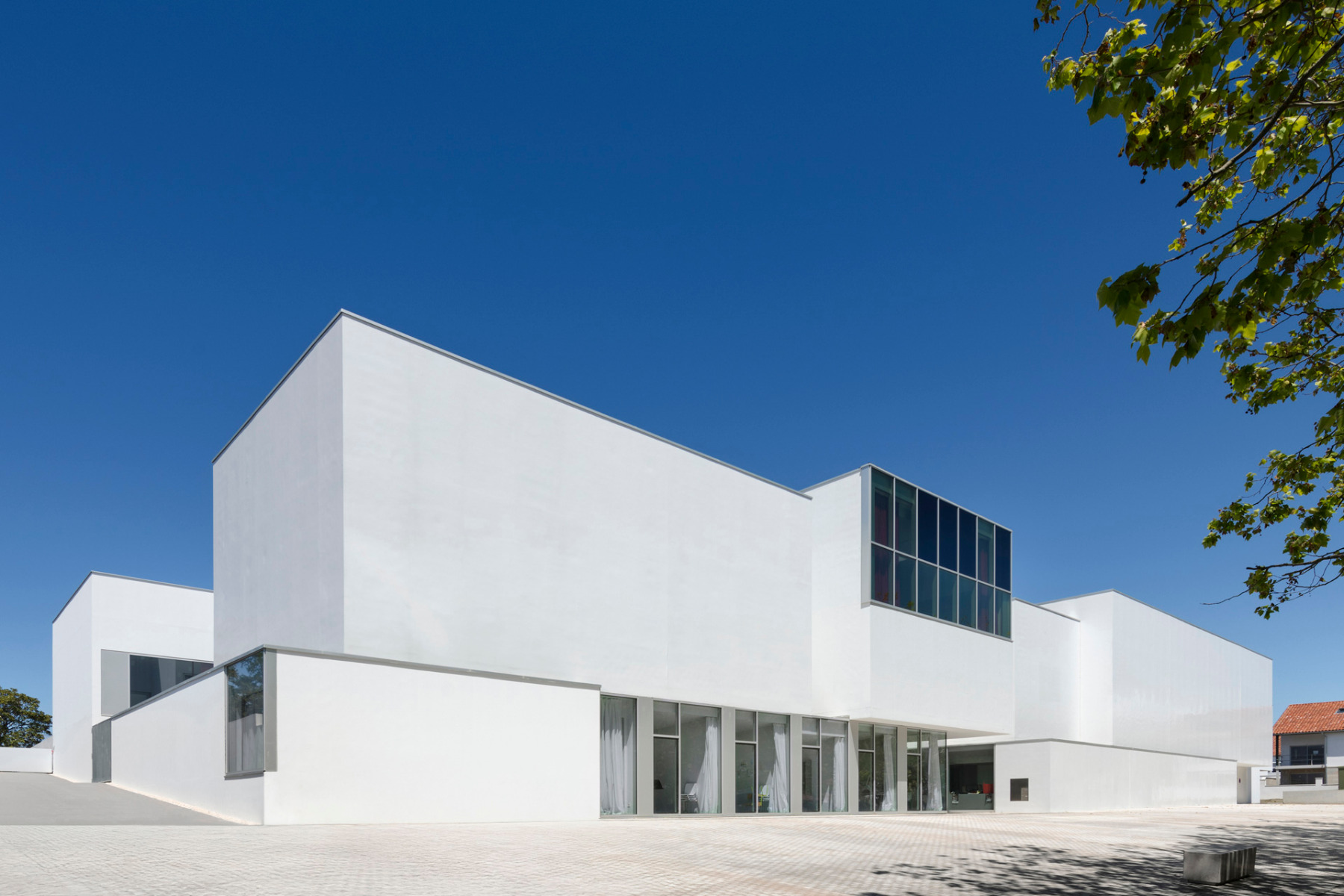 Auf der Eingangsseite zeigt sich der Neubau weiß verputzt und relativ geschlossen. © Eugeni Pons