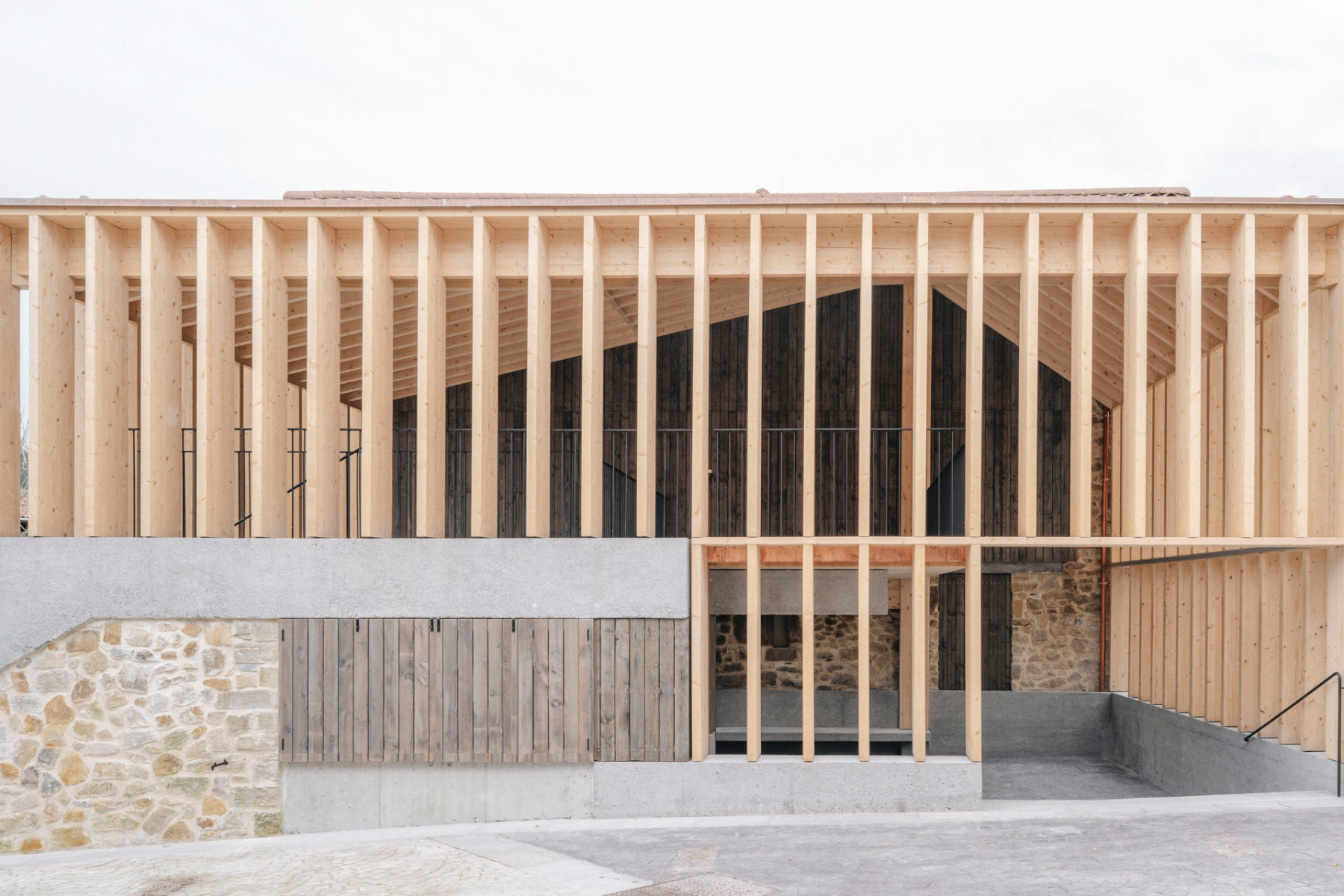 In der Südfassade lässt sich die Komplexität der Konstruktion aus Holz, Beton und altem Mauerwerk erahnen. © Mikel Ibarluzea