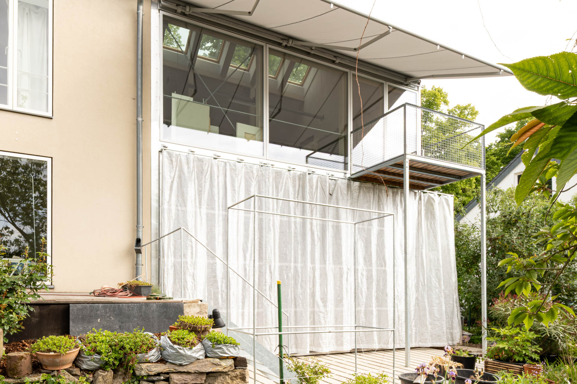 Die Südfassade des Anbaus ist komplett verglast. Horizontale Ausstellmarkisen schützen das Obergeschoss, außen liegende Vorhänge das Erdgeschoss vor Sonne. © Luca Claussen Fotografie 