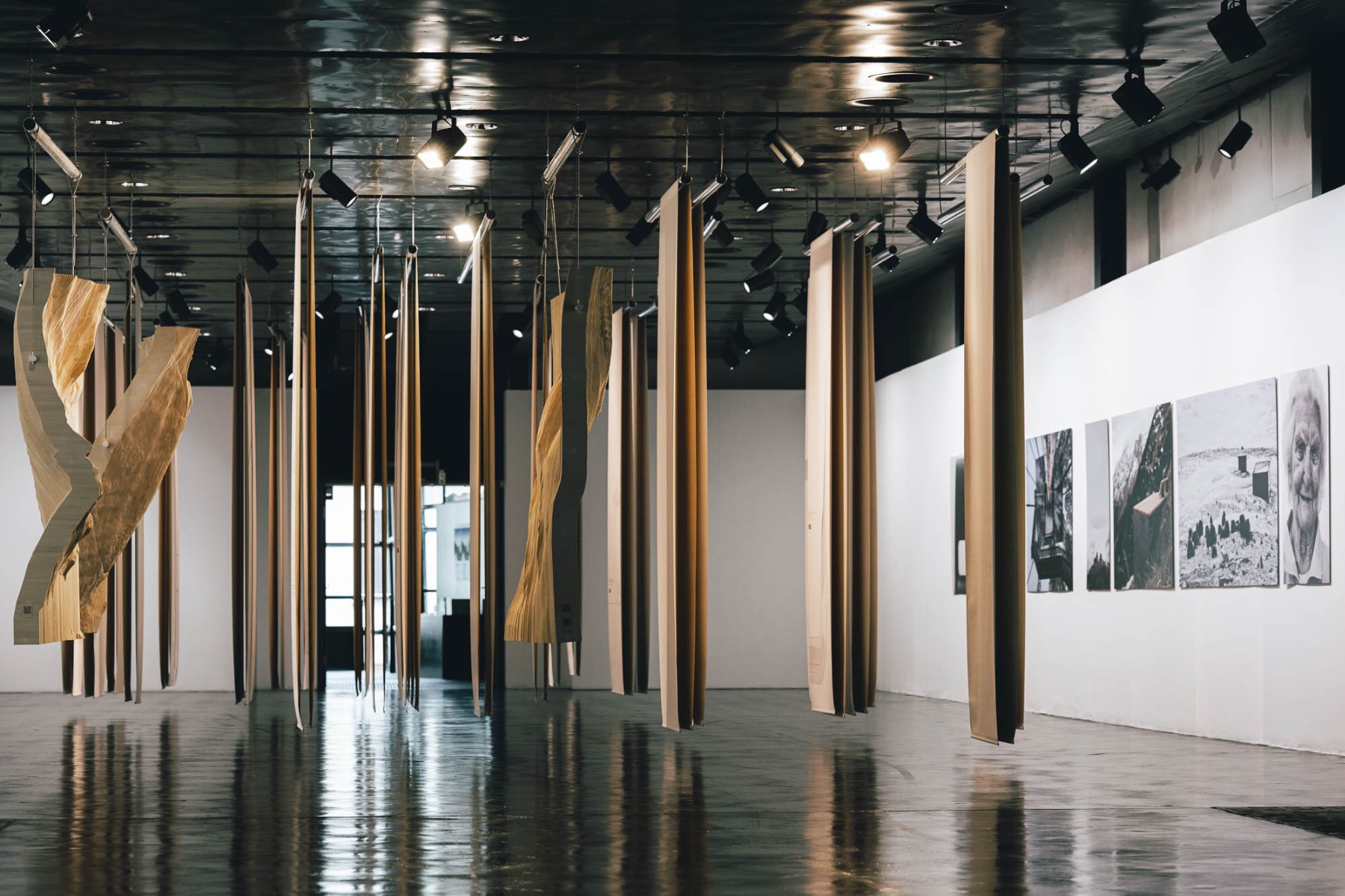 Raummittig hängen mit Zeichnungen und Skizzen bedruckte Textilien von der Decke. © Ivan Bandic