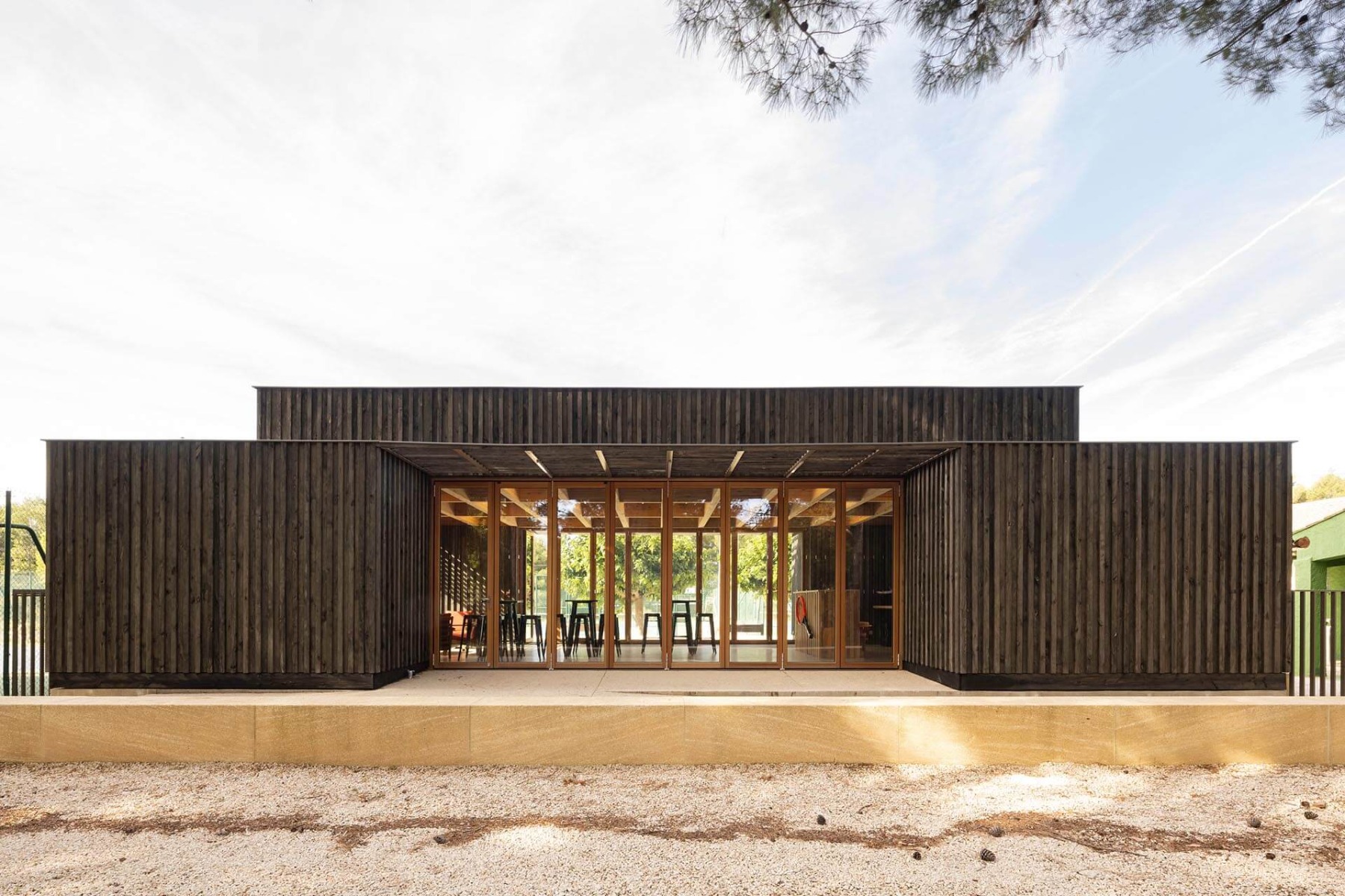 Die Mehrzweckhalle ruht auf einem 40 cm hohen Steinsockel, wodurch der Eindruck eines offenen Torhauses entsteht. © Daniel Sumesgutner für Solarlux GmbH