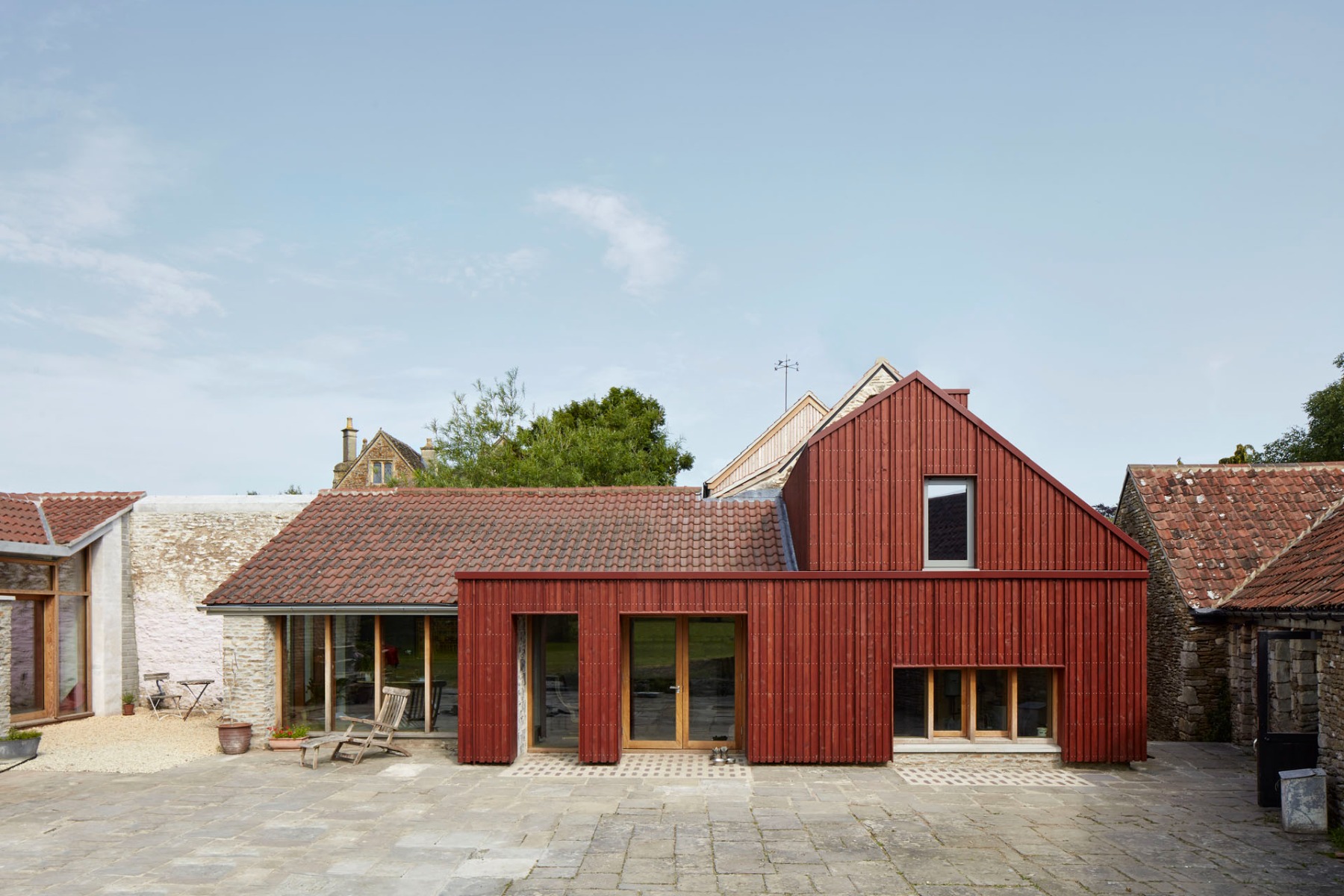 Der&#x20;bestehende&#x20;Anbau&#x20;wurde&#x20;mit&#x20;rot&#x20;lasiertem&#x20;Holz&#x20;neu&#x20;verkleidet.&#x20;&#xA9;&#x20;James&#x20;Brittain