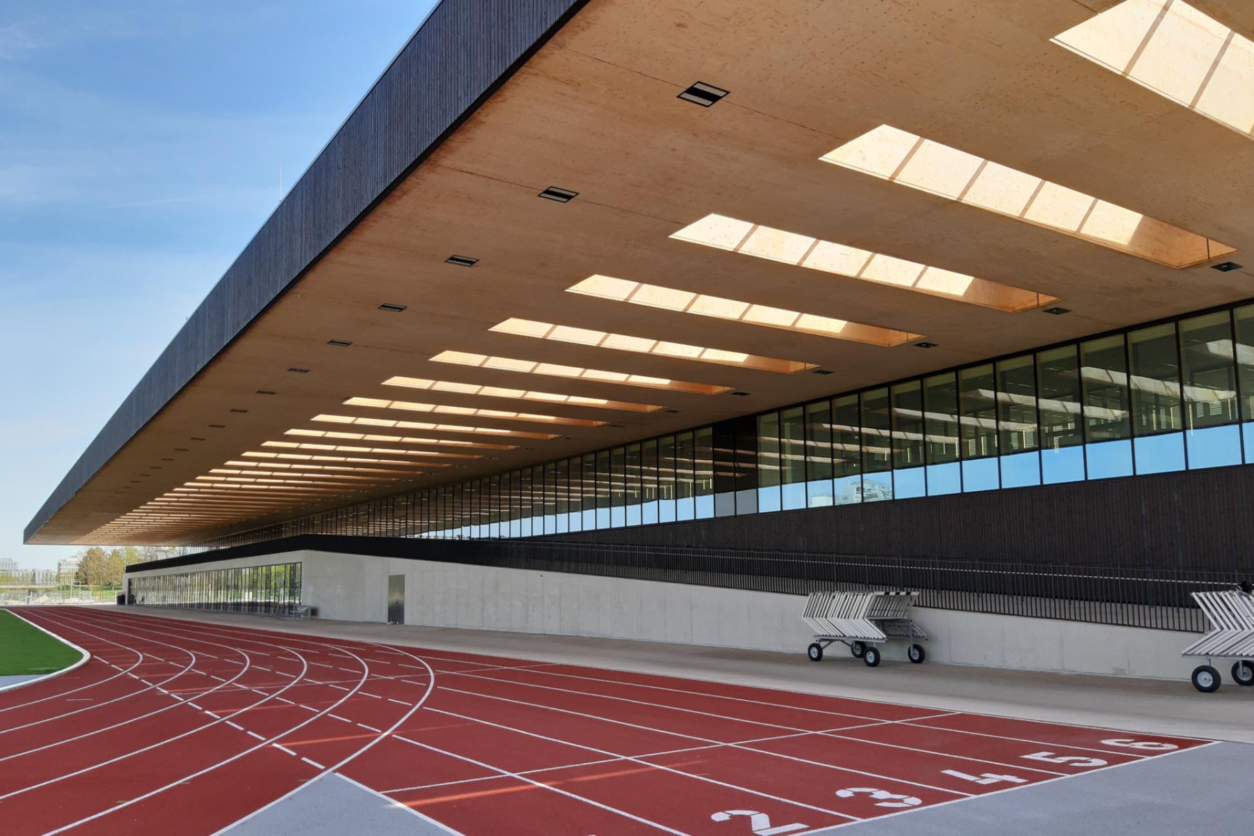 150 m freitragendes Vordach: Gut 18 m Auskragung bilden den Wetterschutz der 100-Meter-Bahn am TUM Sportcampus im Olympiapark München – einem der größten Holzbaukomplexe Europas. © Rubner