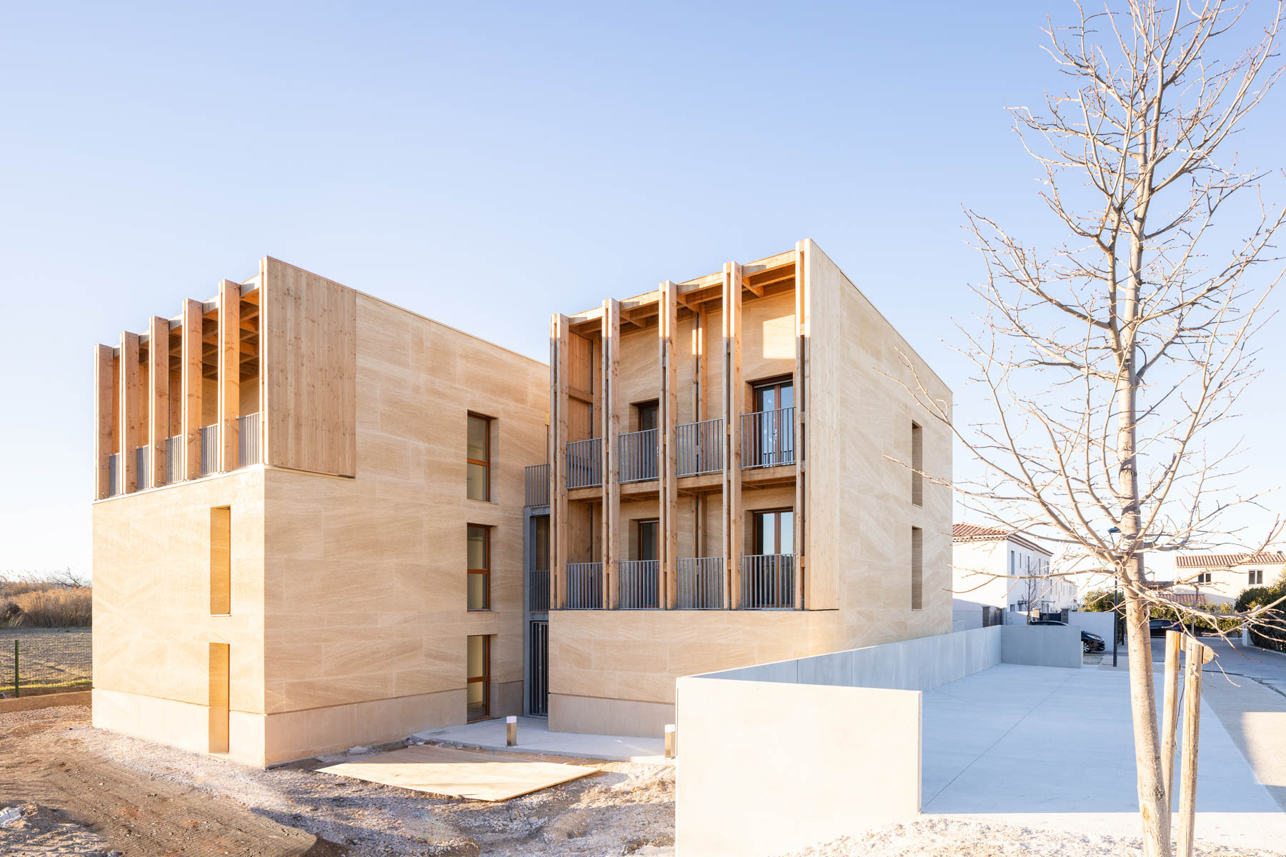 Für ein soziales Wohnbauprojekt mit acht Einheiten kombinierte Atelier Régis Roudil Beton und Stein mit Holz. © Florence Vesval