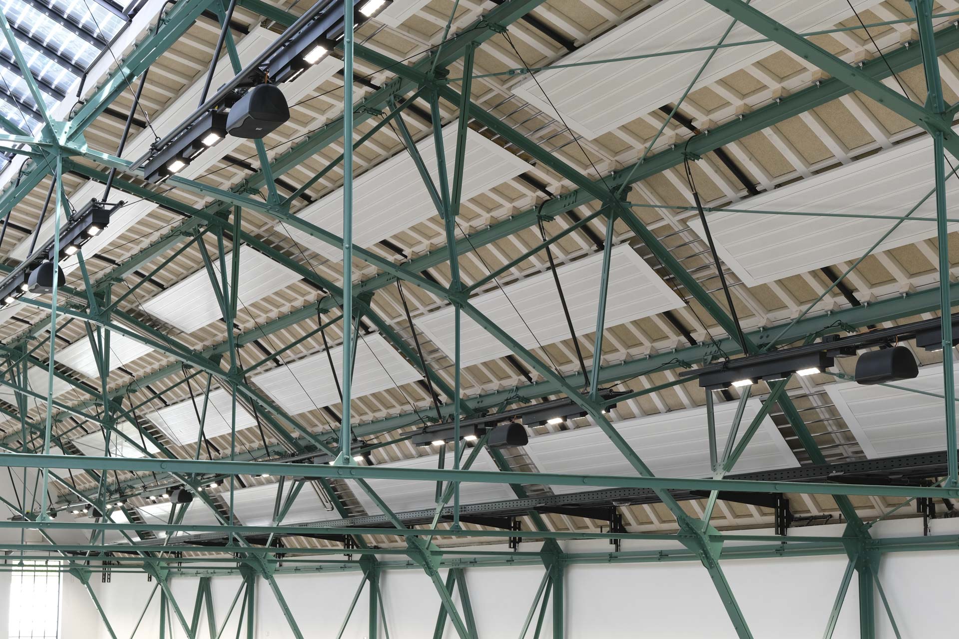 Historisches grünes Stahlfachwerk trägt neues Dach, Aufnahme aus dem Innenraum.