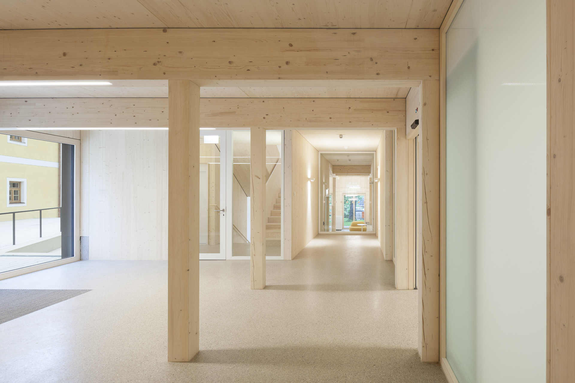 Heller, lichtdurchfluteter Eingangsbereich mit viel Holz und klarer Gangführung.