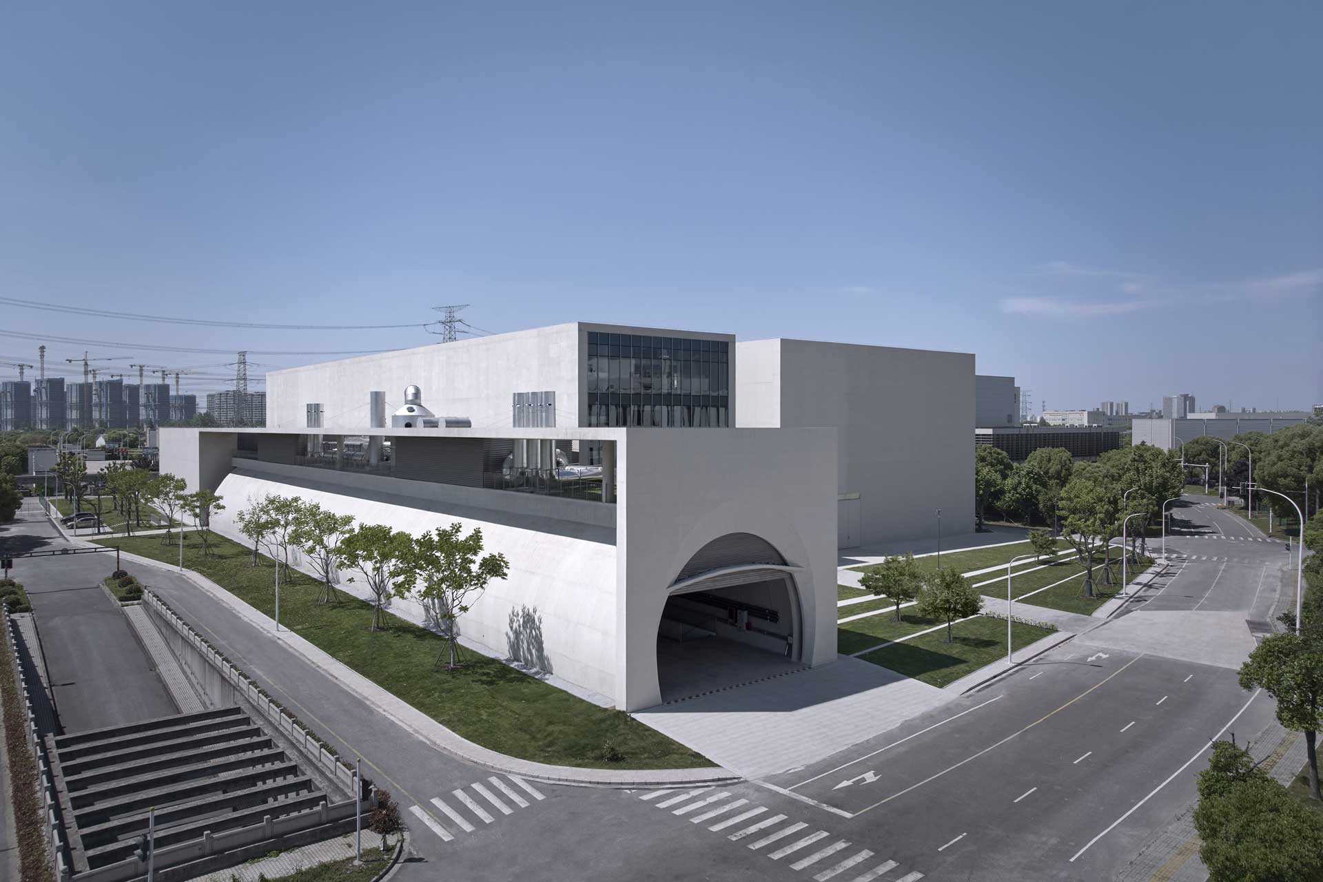 Massives Geb&auml;ude mit durchgehender Betonfassade, das an einer Stra&szlig;enecke steht.
