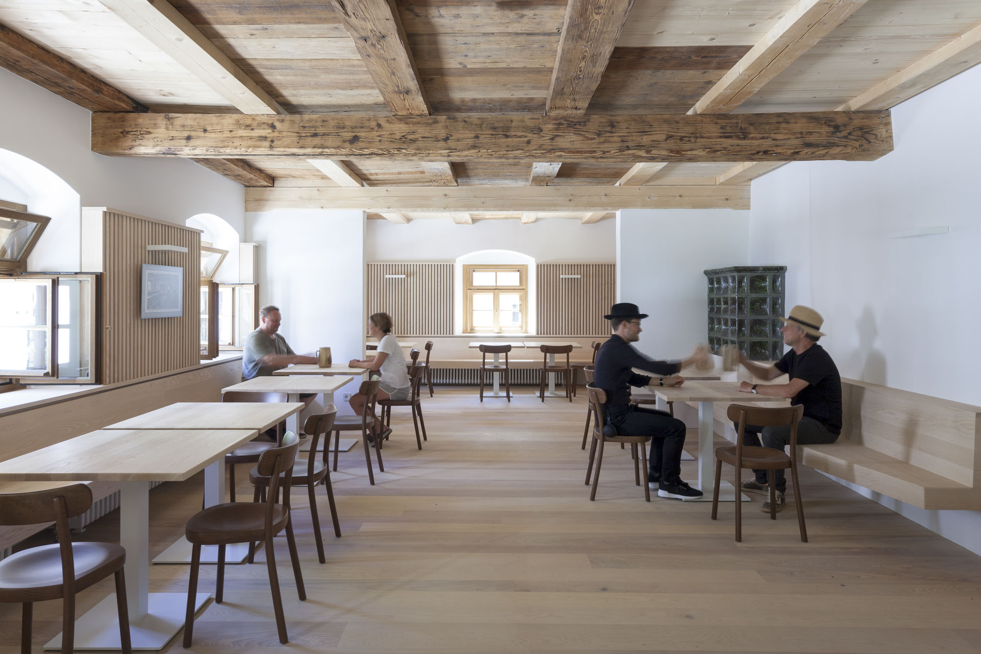 Innenraum mit alter Holzdecke, Café-Atmosphäre, Gäste sitzen an Tischen.