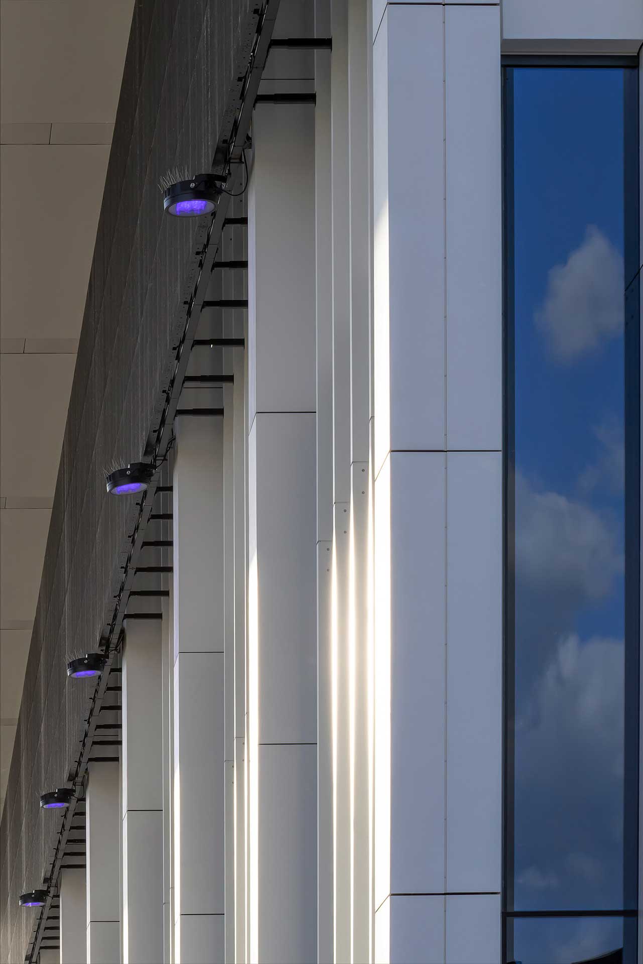 Längsansicht einer Hallenfassade mit regelmäßig angeordneten Lichtspots.