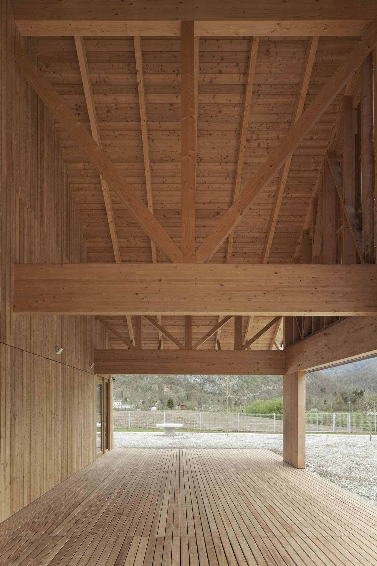 Überdachte Holzterrasse an der Giebelseite des Hauses, Ausblick in die umliegende Landschaft.