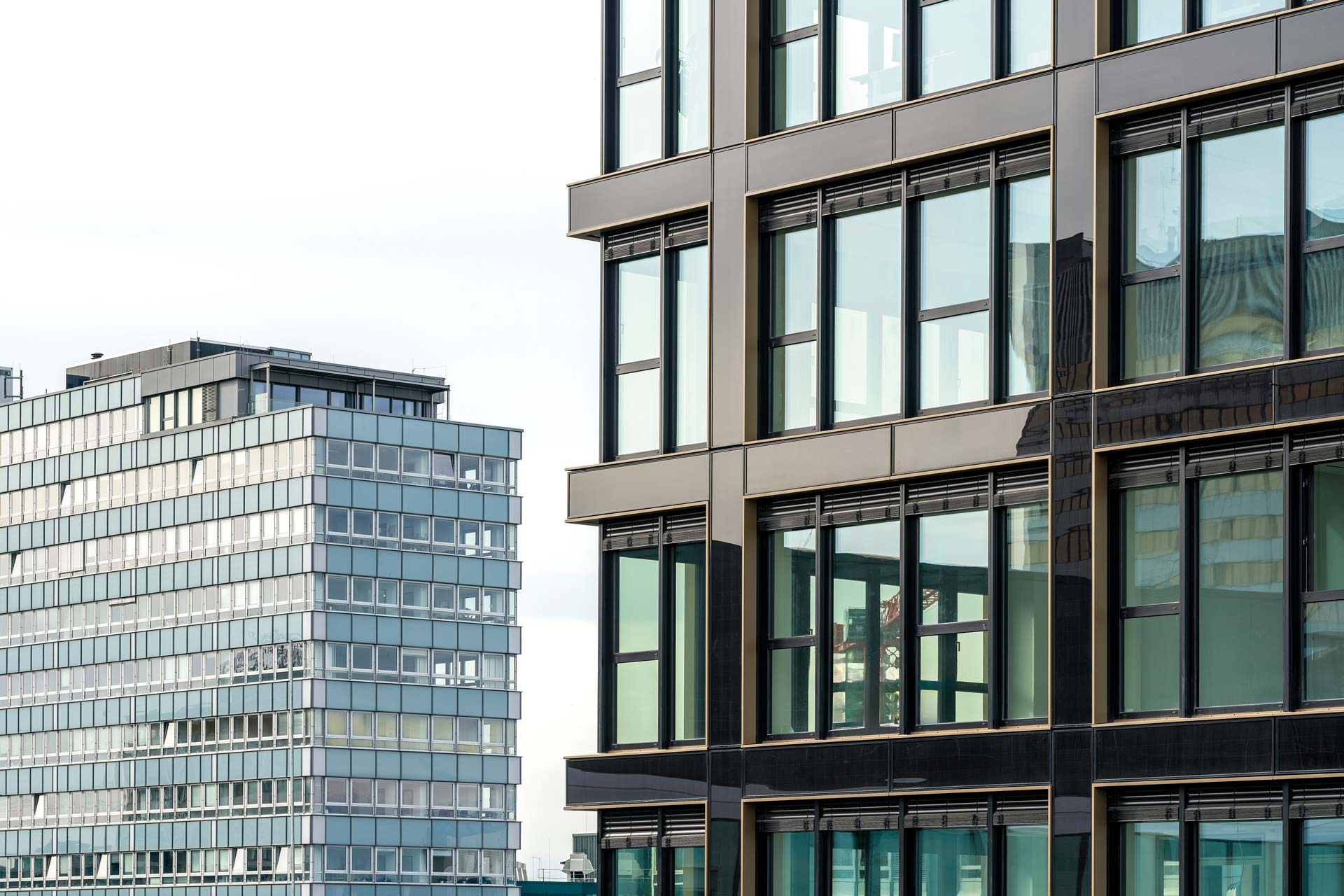 Fassaden zweier Bürogebäude, die nebeneinander stehen.