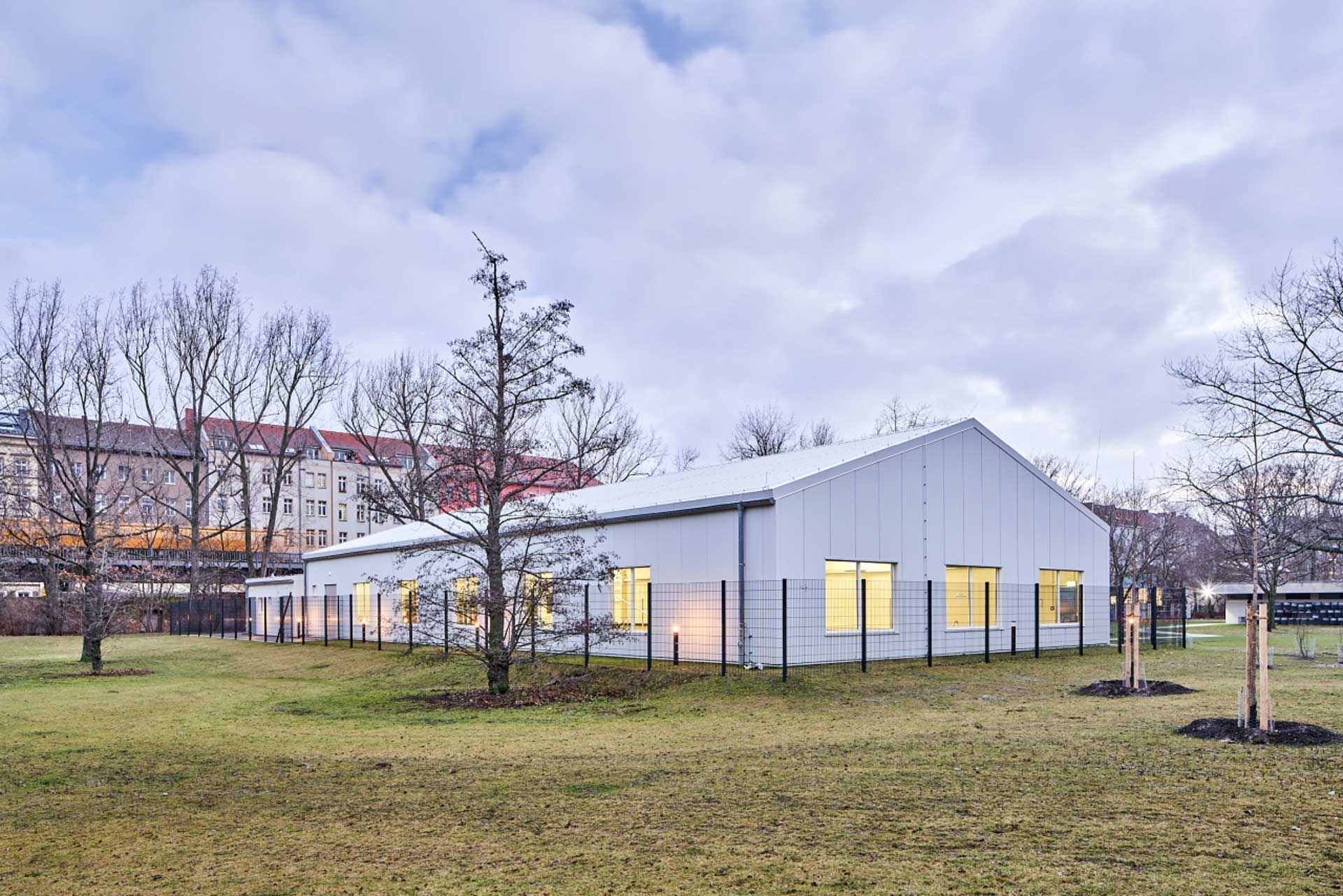 Weiße, zeltähnliche Halle auf einer Wiese.