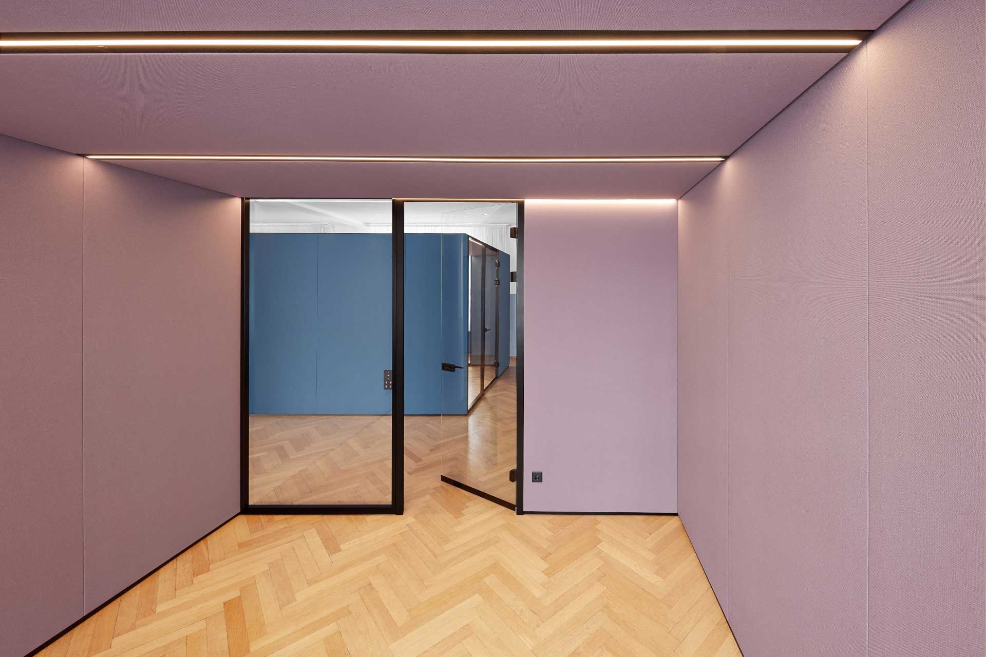 Leerer Raum mit lilafarbenen Wänden und einer offen stehenden Glastür.
