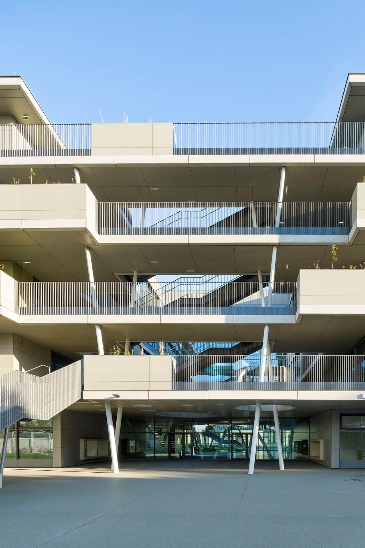 Vierstöckiges, helles Haus mit Außentreppe und Außengeländer.