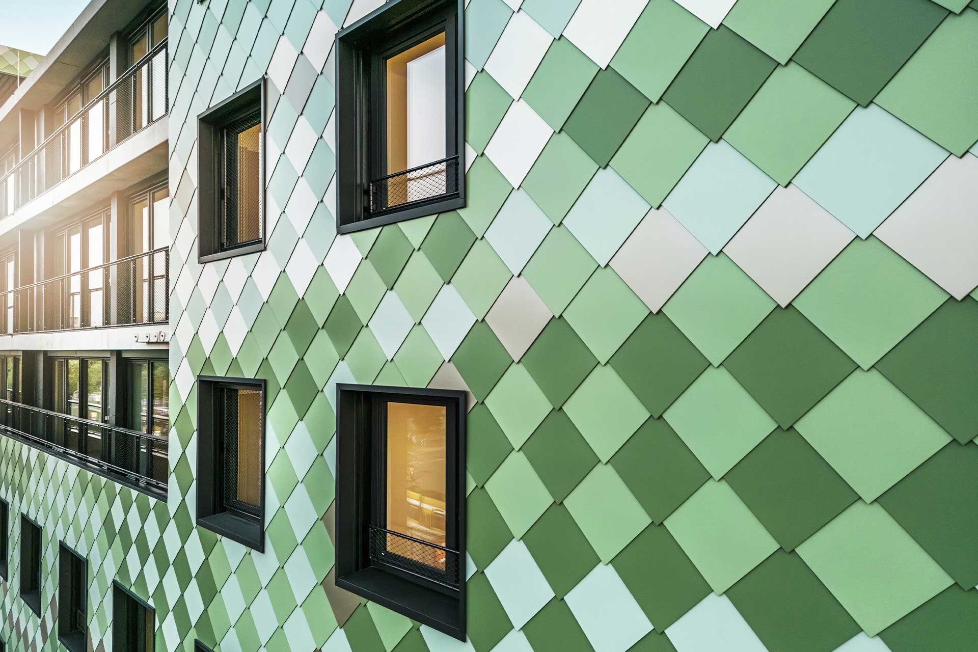 Fassade eines Hauses mit Rauten in verschiedenen Grüntönen.