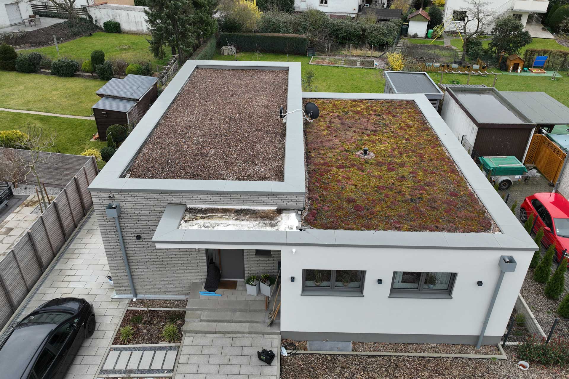 Bungalow mit Gr&uuml;ndach in einer Wohnsiedlung.