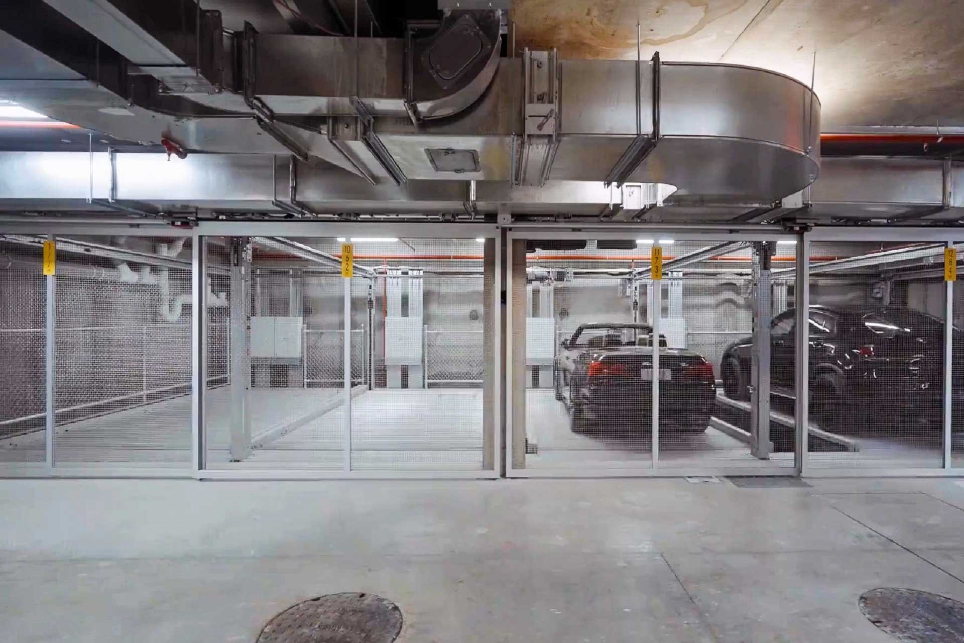 Absperrbare Tiefgaragenplätze. Auf zweien steht je ein schwarzes Auto.