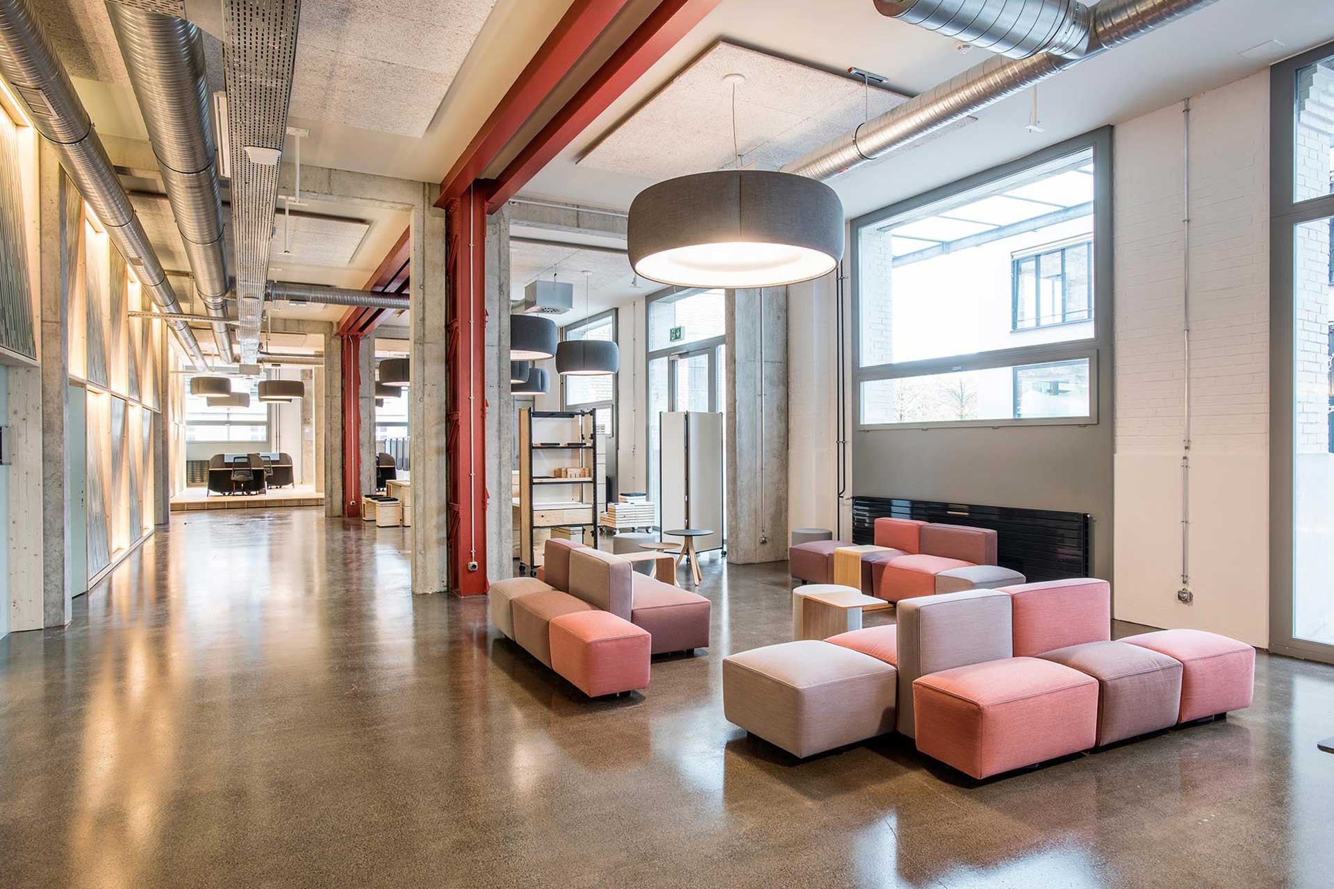 Aufenthaltsbereich mit niedrigen Sofas in einem Coworking Space.