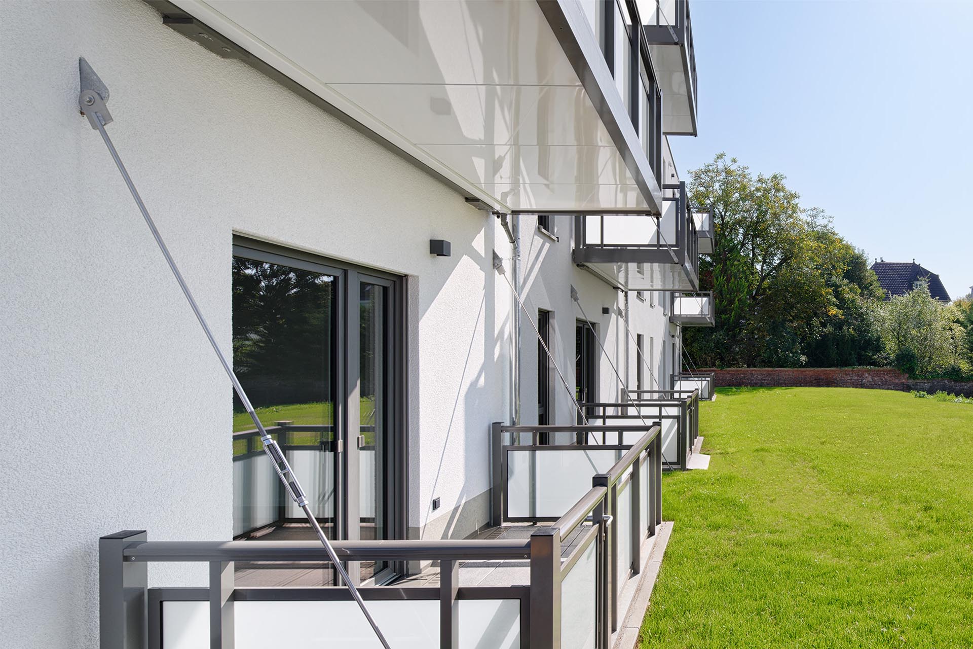 Balkone eines Mehrfamilienhauses mit filigranem Stahlseil.