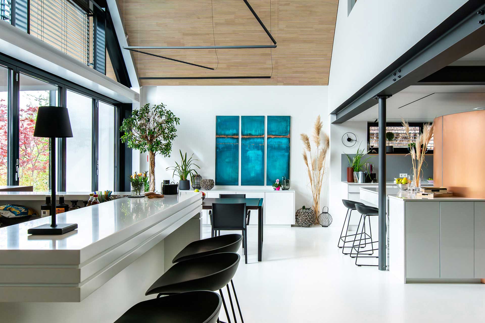 Offener Wohn-Essbereich mit Küche, Esstisch und einer Bar im Vordergrund.