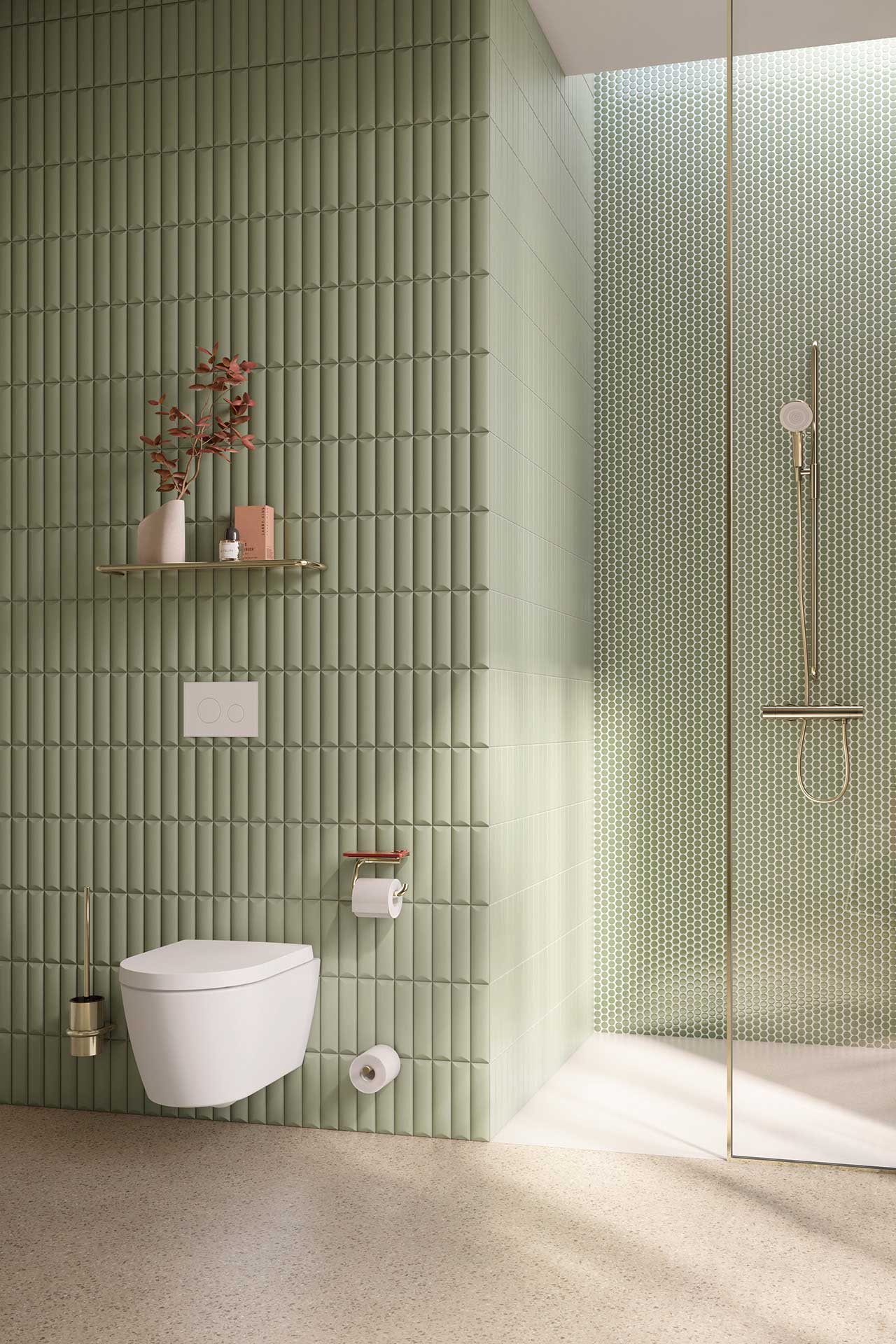 Badezimmer mit grünen Fliesen, einer Dursche mit Glastür und einer schwebenden Toilette.