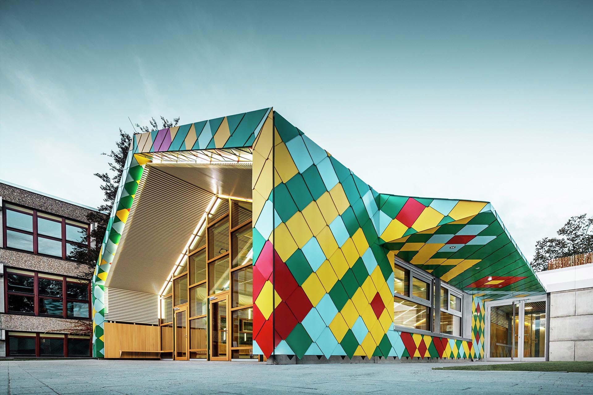 Quadratisches Gebäude mit Flachdach und Wandrauten als Fassadenverkleidung.