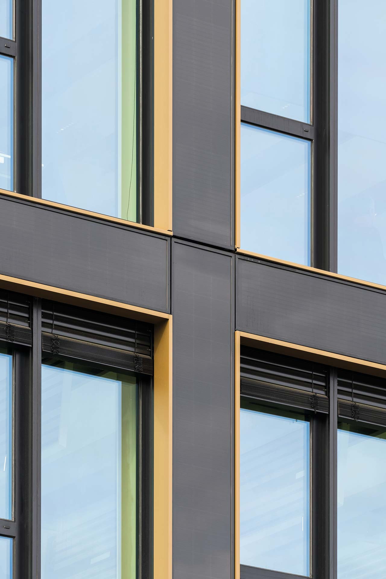 Close up einer Fassade mit bronzefarbenen Einfassungen der Fenster.