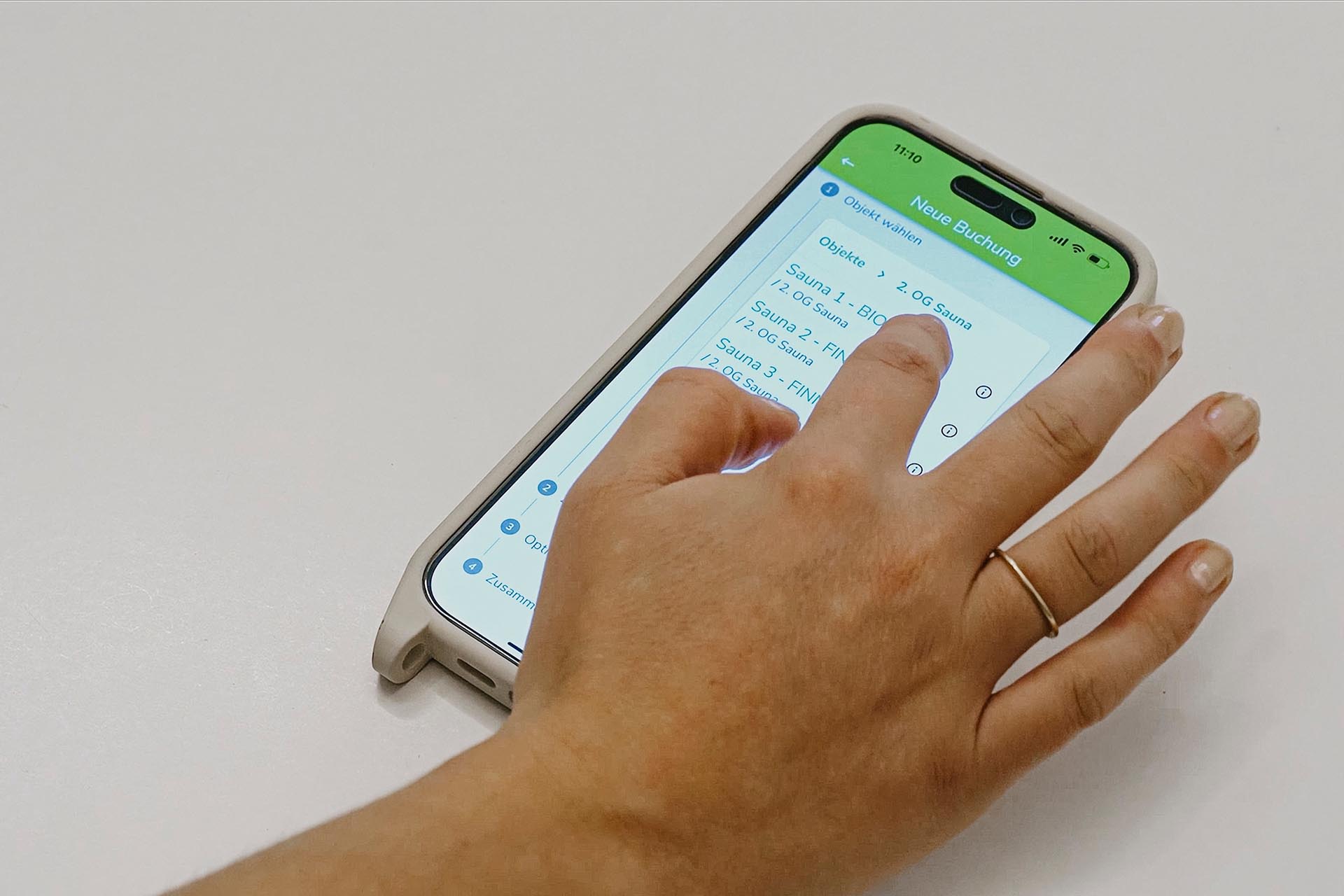 Eine Hand bedient eine App auf einem Smartphone.