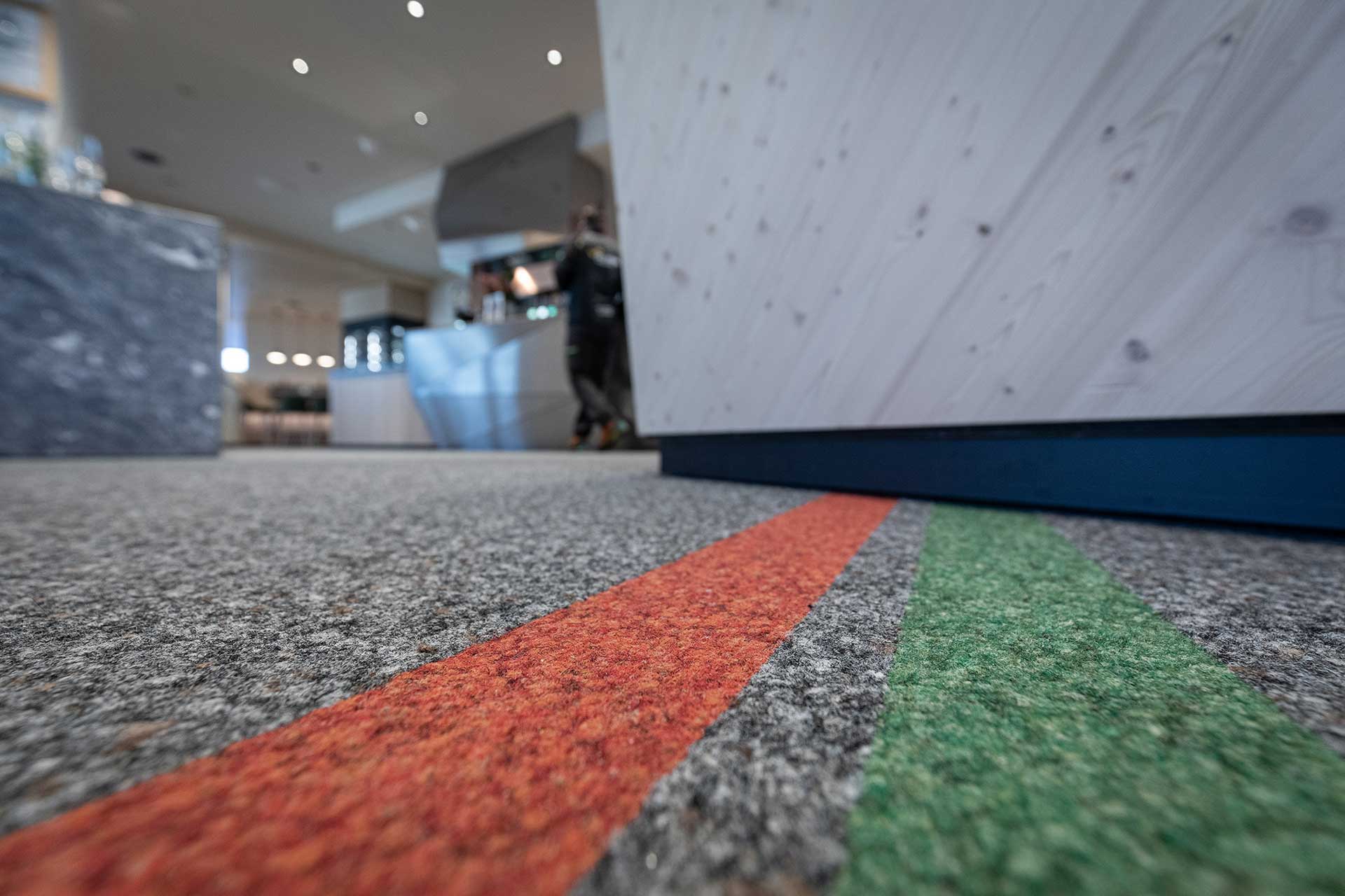 Robuster Bodenbelag mit einem roten und einem grünen Striefen.