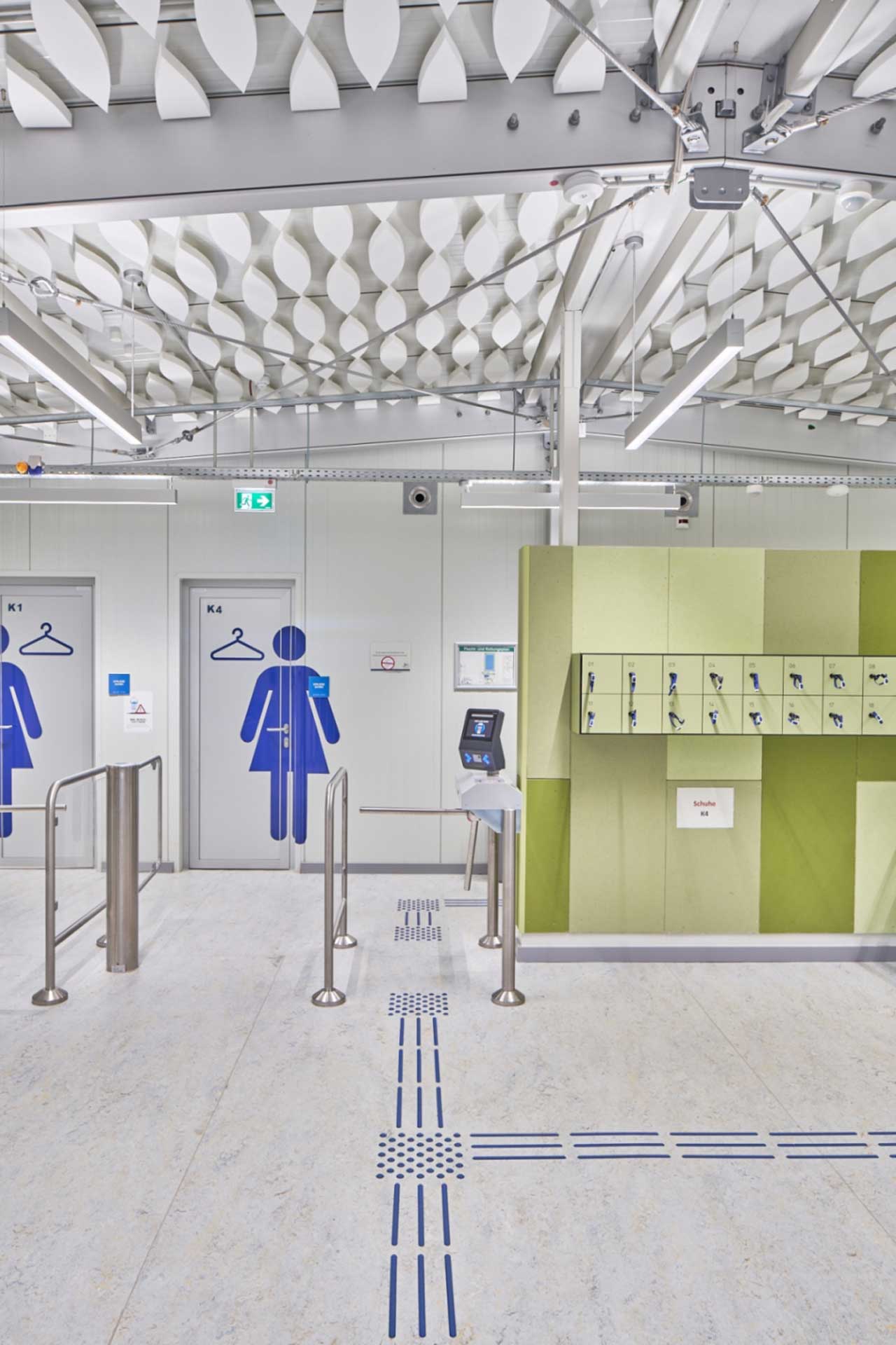 Foyer eines Schwimmbades mit Drehkreuz, Spinden und den Eingängen zu den Umkleiden.
