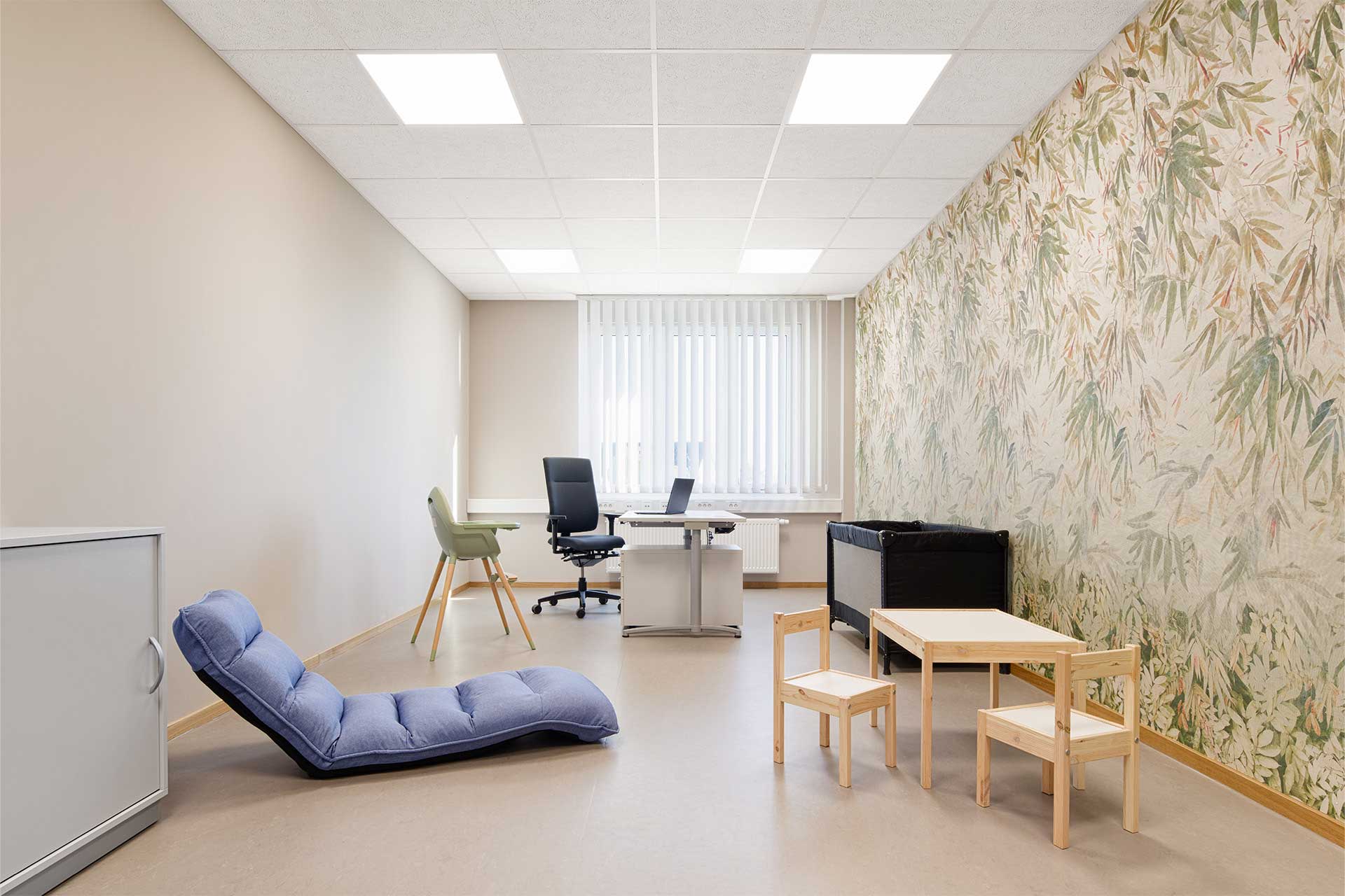 Raum mit einem Arbeitsplatz, einer modernen Liegesessel und Tisch und Stühlen für Kinder.