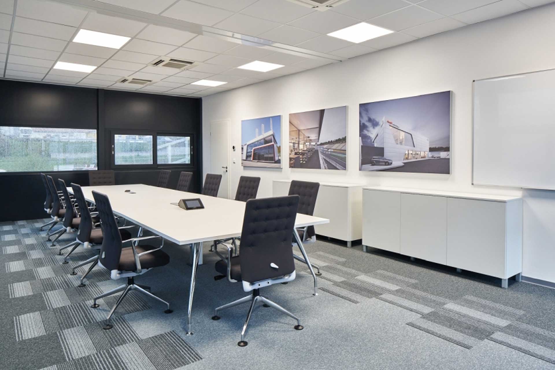 Sanitärbereich eines Büros mit Waschbecken, Toilette und Bidet sowie mit Holzboden und blauen Wänden.