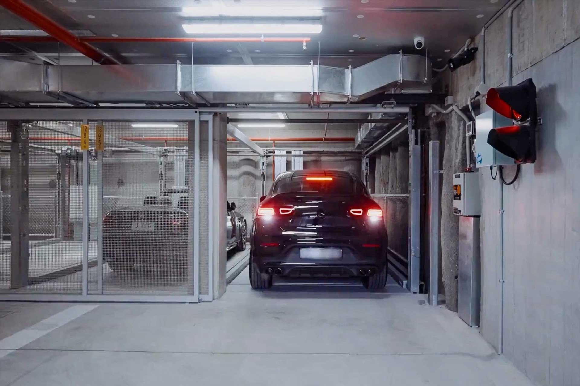 Ein schwarzes Auto fährt in einen absperrbaren Tiefgaragenplatz.