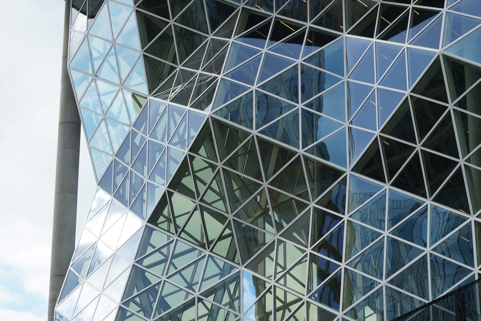 Unregelmäßige Glasfassade aus gleichmäßigen Dreiecken.