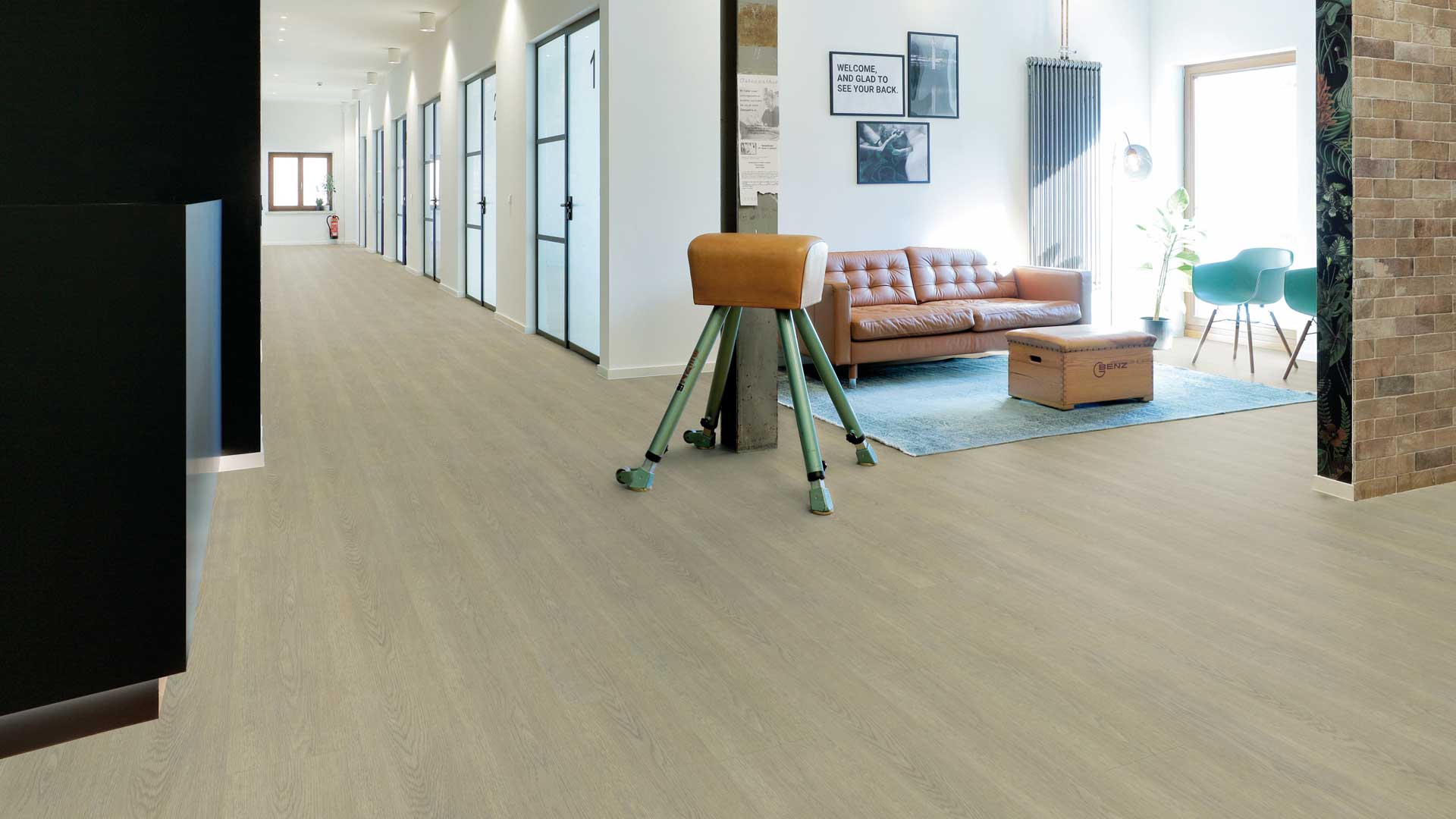 Breiter Gang eines B&uuml;rogeb&auml;udes mit Sitzecke und Sofa.